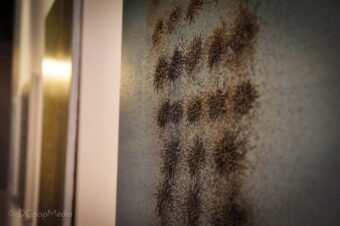 Field Array Installation view of repeated magnetic clusters formed by iron shavings across a panel surface