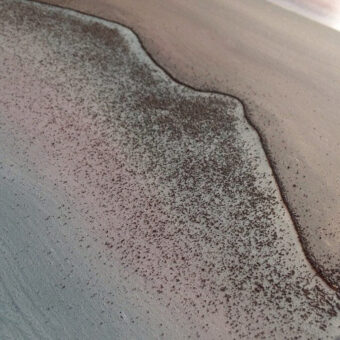 Field Boundary Close-up of iron shavings dispersing along a curved boundary across a pale surface