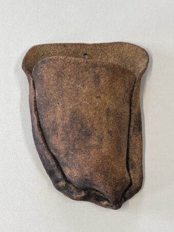 Earthen Fold Wall-mounted ceramic sculpture with a folded pouch-like form, rough unglazed surface, natural clay tones, and darkened edges from firing.